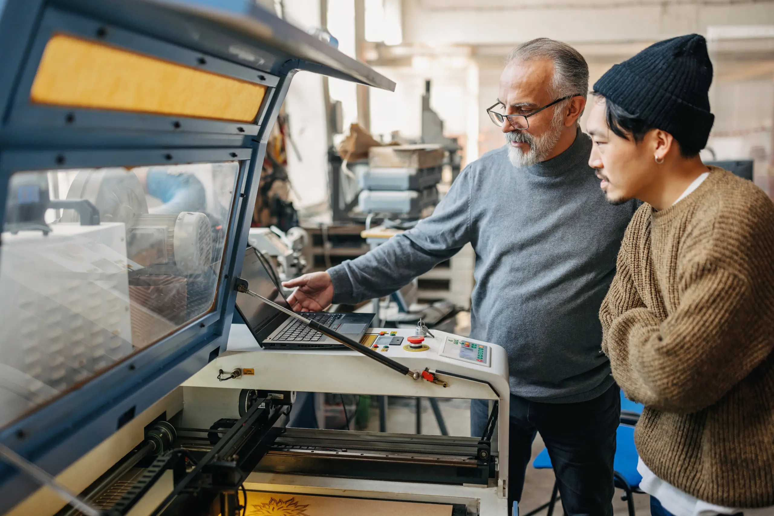 Photo of man teaching student how to use a laser