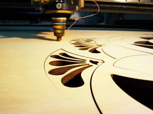 Photo of a wood sign being created with a laser